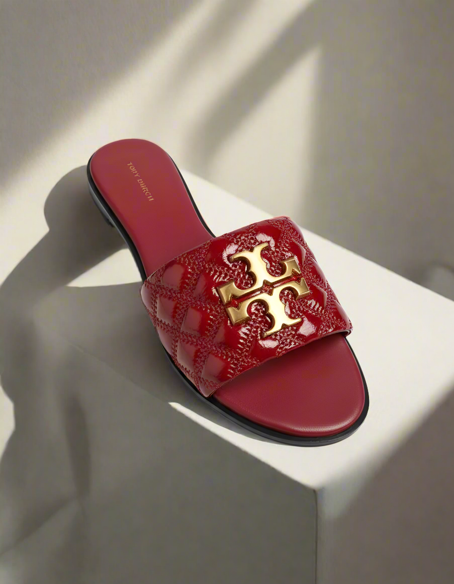 Red slide sandal with gold logo on a white background