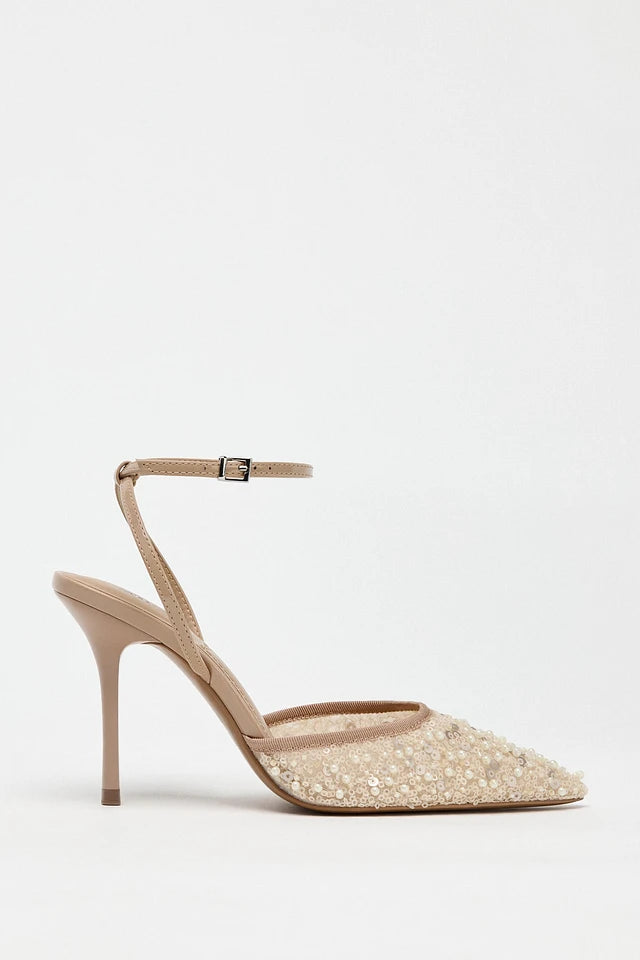 Beige high-heeled shoe with glittery sole on a white background